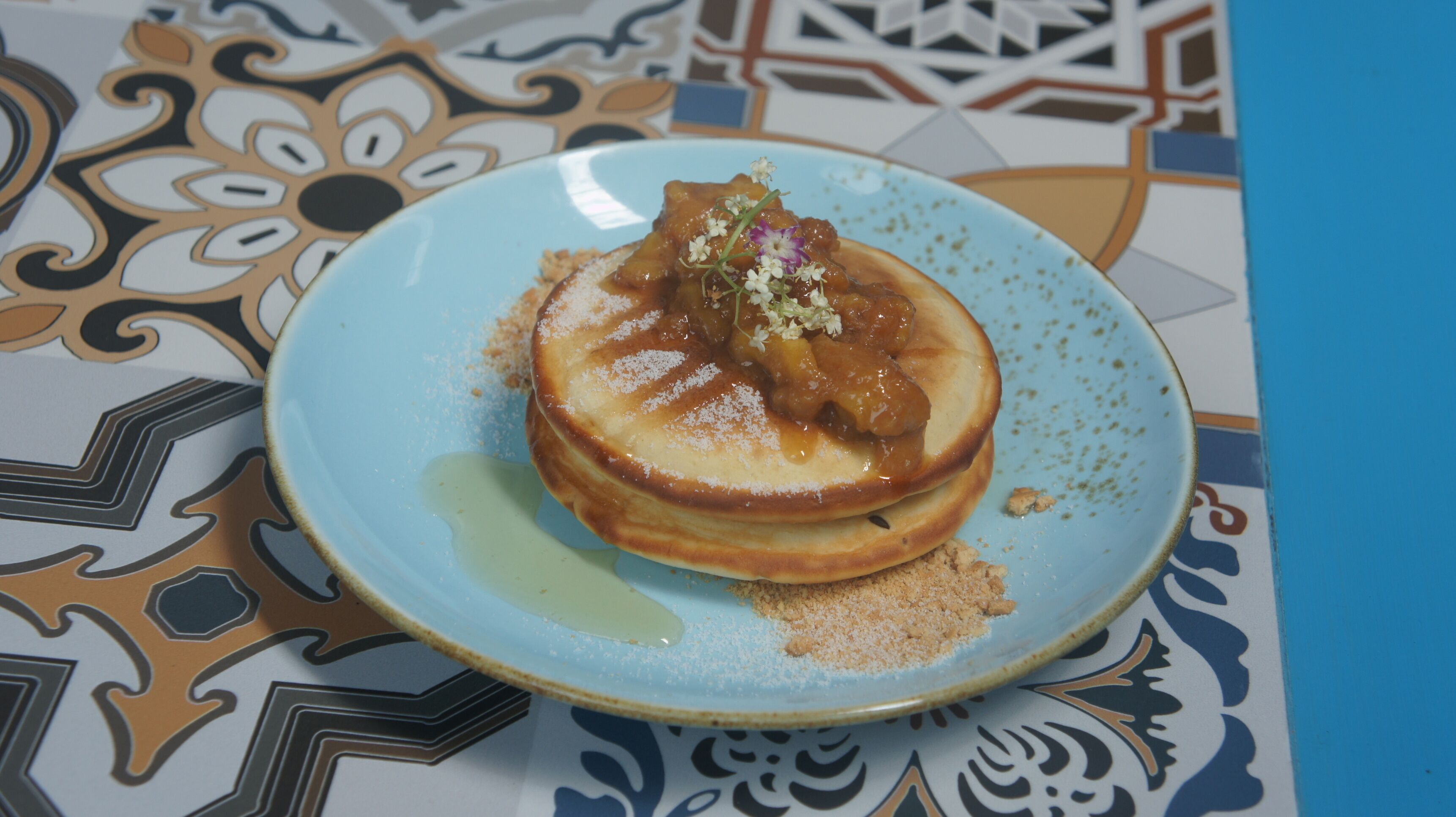 Un plato con un postre sobre una mesa con mantel estampado.