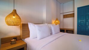 A neatly made bed with white linens, two bedside lamps, and a wooden nightstand with a tissue box. - Sunset Paradise Canggu (Canggu)
