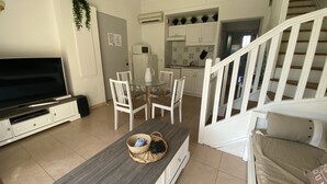 A living room with a TV, a glass table, and chairs. There is a staircase leading to another level. - LS1-295 MARINADO Mouriès (Mouriès)
