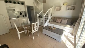 A compact living space with a kitchen, dining area, and a sofa with 'Beach Club La Sel Lounge' pillows. - LS1-295 MARINADO Mouriès (Mouriès)