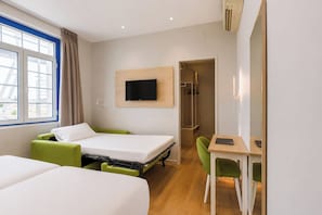 A hotel room with two beds, a desk, a TV, and a walk-in closet. - Spirit Hotel Fonte Real (Monte Real)