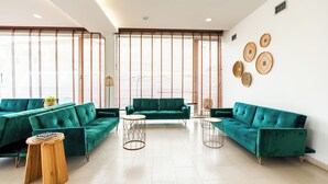 A modern living room with two green sofas, a wooden coffee table, and a round side table. - Spirit Hotel Fonte Real (Monte Real)