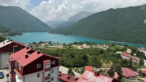A lakeside village with buildings and a view of a lake surrounded by mountains.
