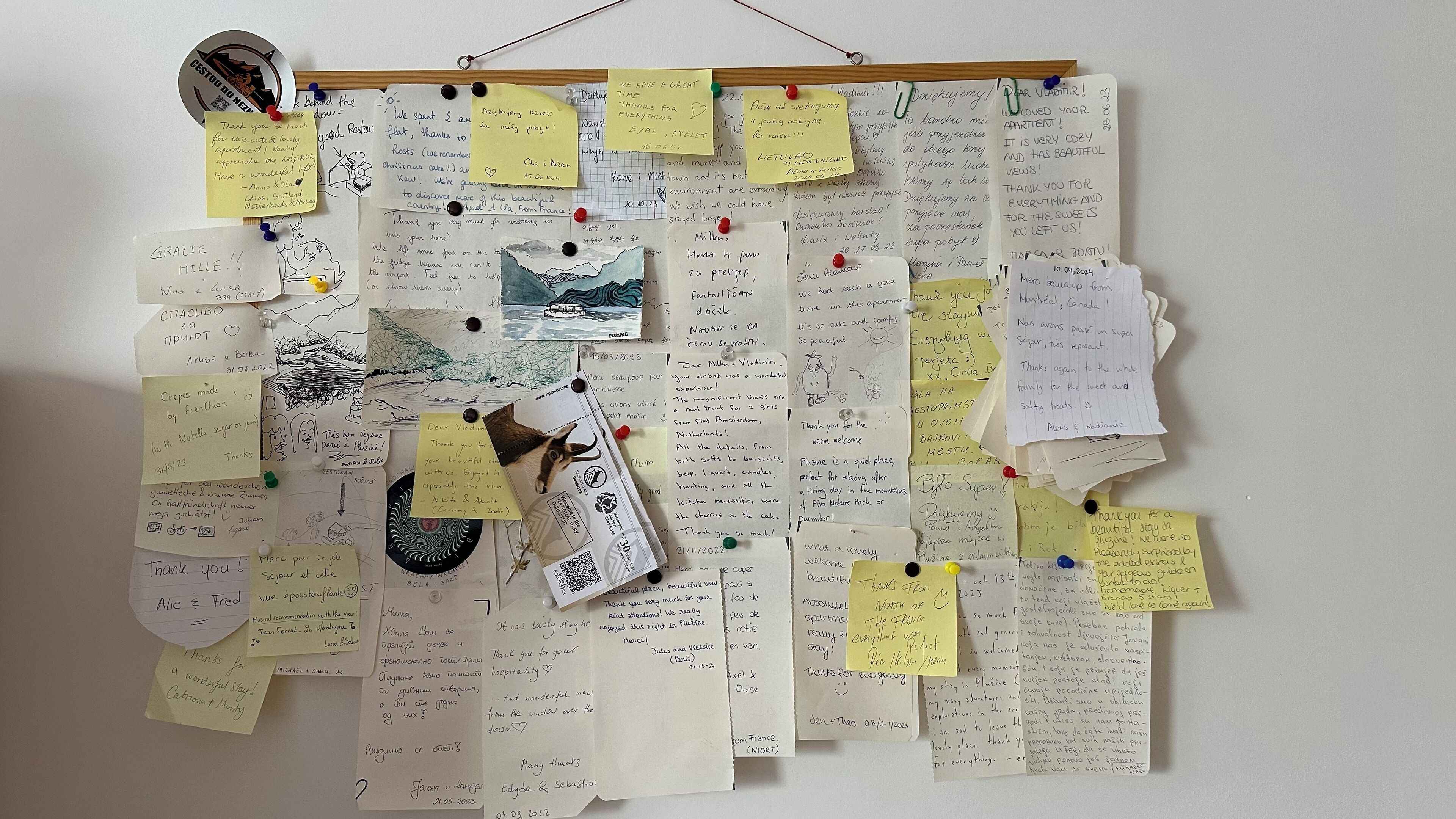 Un mur sur lequel sont accrochés divers messages, notamment des notes manuscrites et des dessins.