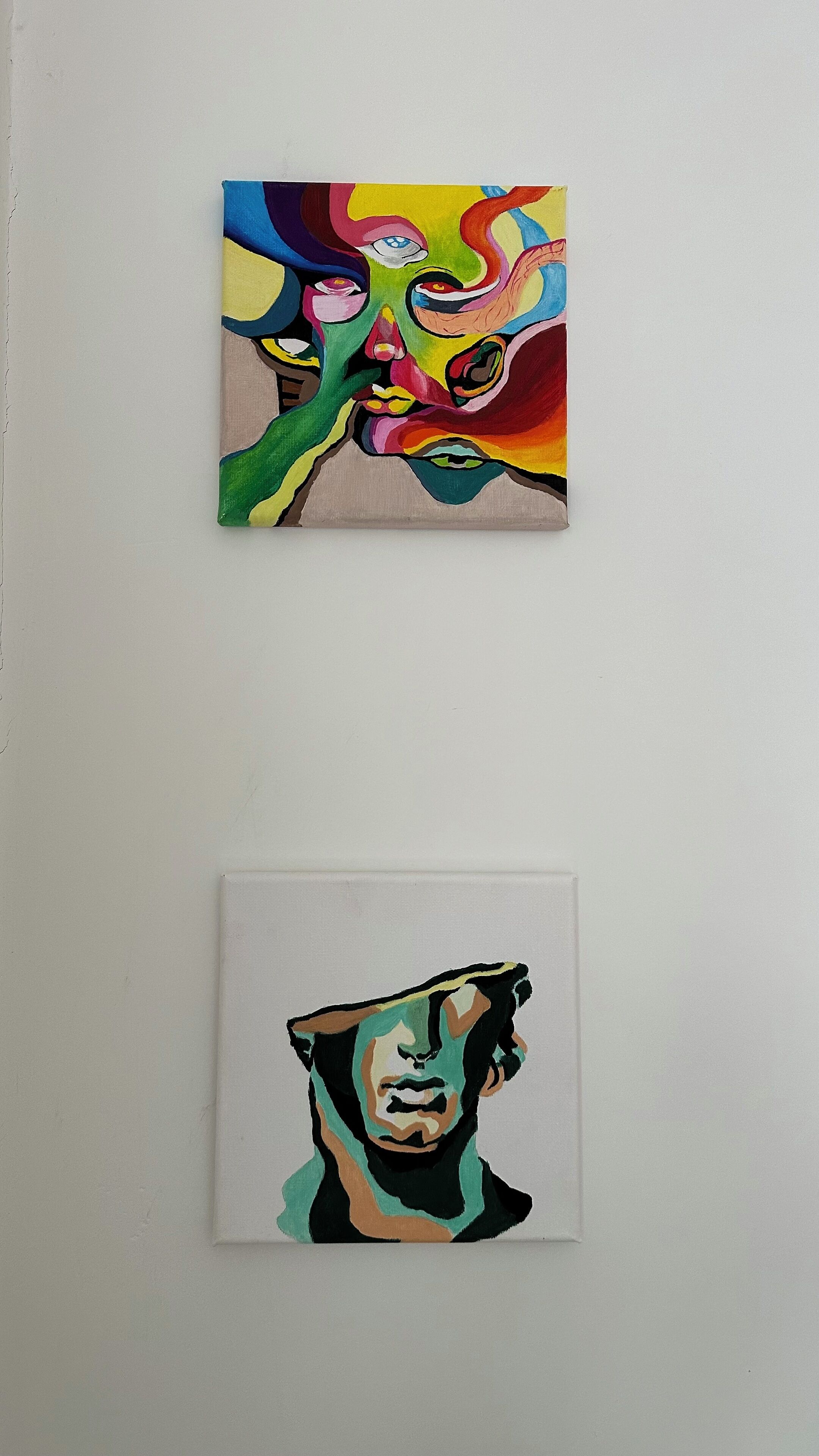 Zwei Gemälde an einer Wand.
