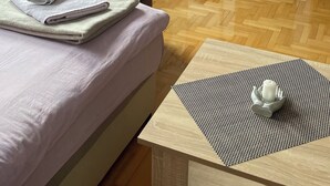 A neatly arranged bedroom with a bed, a TV, a bookshelf, and a window.