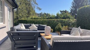 An outdoor seating area with a sofa and chairs, a table, and a decorative vase. - Spacious 5-bed House - Garden, Parking & Bbq (Newcastle Upper)