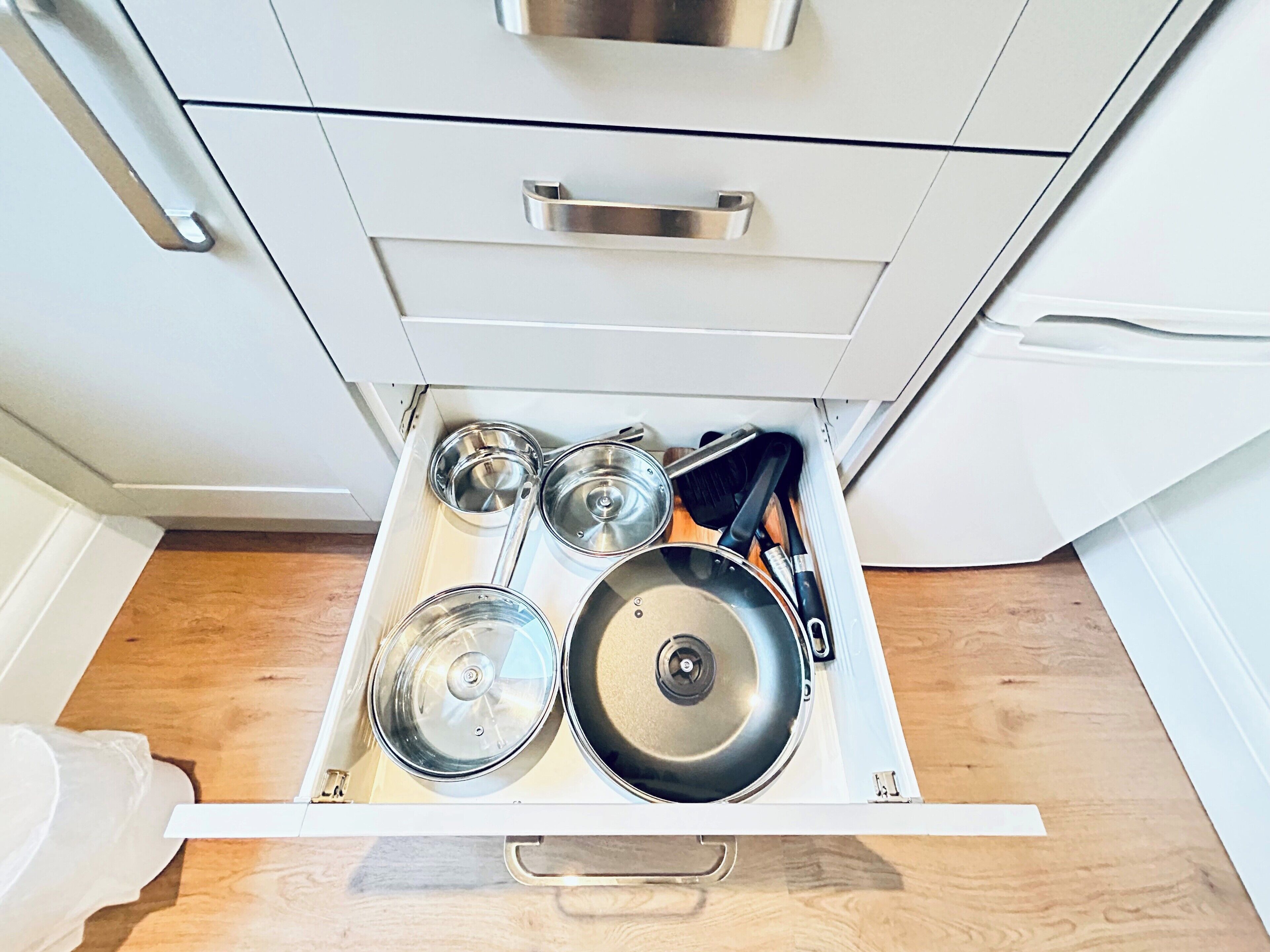 Un cassetto della cucina con pentole, padelle e utensili.