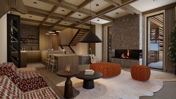 A modern living room with a fireplace, a sofa, ottomans, a coffee table, and a kitchen area with a staircase.