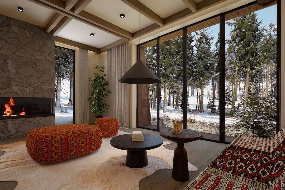 Una sala de estar moderna con chimenea de piedra, ventanas amplias y vistas a un bosque nevado.