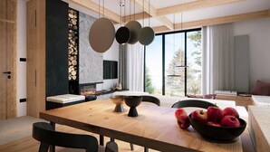 Un espace repas moderne avec une table en bois, des chaises noires et un saladier rempli de pommes.