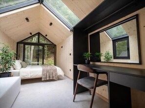 A bedroom with a bed, a desk, and a chair, a large window, and a mirror. - Mountain Retreat by Dukley (Kolasin)
