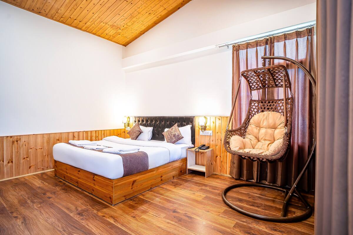 A bedroom with a wooden bed, a hanging chair, and a nightstand.