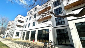 A modern building with large windows and a bike parked outside. - The LUX~ 1 Block to the Beach!! (Traverse City)