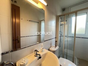 A modern bathroom with a large white sink, a mirror, and a glass-enclosed shower. - Detached house in Calonge with private pool and parking (Calonge)