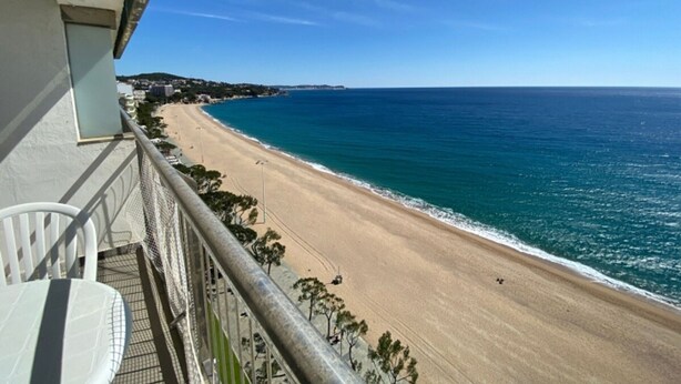 Un balcon avec vue sur une plage et l’océan.