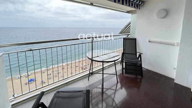 A balcony with a view of the beach and ocean.