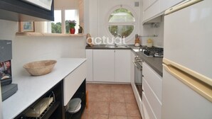 A compact kitchen with white cabinets, a microwave, a sink, and a window. - Apartment near beach with terrace and parking, optional aircon (Platja d'Aro)