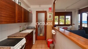A kitchen with wooden cabinets, a stove, and a sink.
