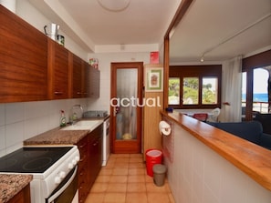 Una cocina con armarios de madera, estufa y lavaplatos.