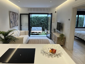 Ein modernes Schlafzimmer mit Bett, Fernseher und Blick ins Freie.