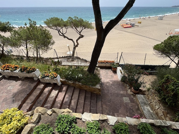 A stone staircase leading to a beach with a clear view of the ocean.