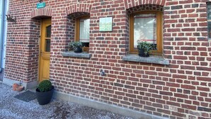 Un edificio de ladrillo con un letrero que dice "GITE RURAL" y una pequeña ventana con una planta.