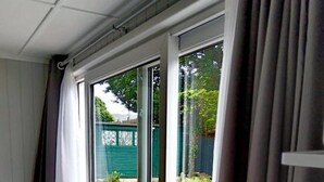 Une pièce dotée d’une porte-fenêtre coulissante donnant sur un jardin.