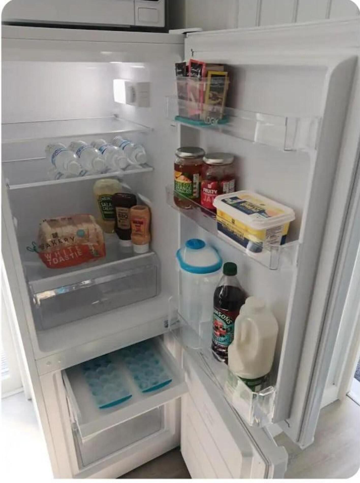An open refrigerator with various food items and beverages.