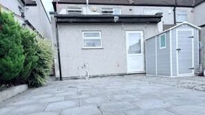 Ein Wohngebiet mit befestigter Auffahrt, einem Haus mit weißer Tür und einem Schuppen.