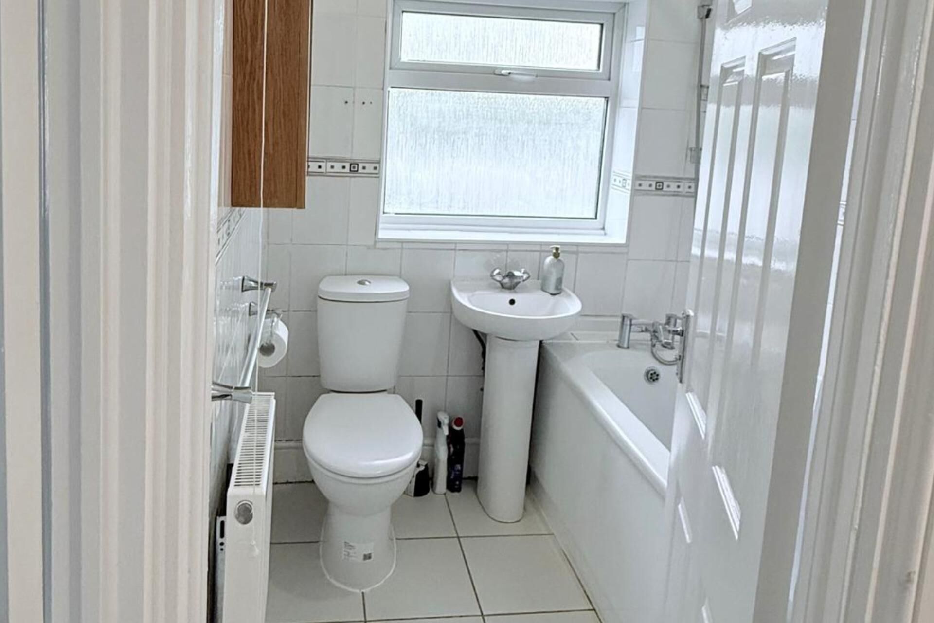 Une petite salle de bain comprenant des toilettes, un lavabo et une baignoire.