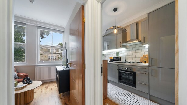 Een moderne keuken met uitzicht, houten vloeren en een ingebouwde oven.