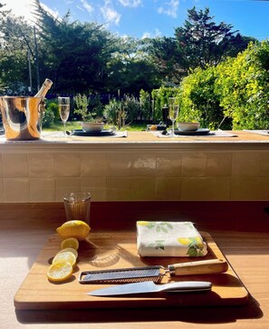 A kitchen counter with a cutting board, lemon, knife, and a cloth with a lemon pattern.