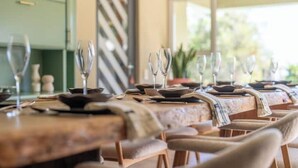 A dining area with tables set for a meal, chairs, and a view of the outdoors. - Spacious Kinvara Villa with AC, Gym, Pool & Mountain Views (Cape Town)