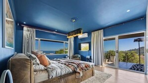 A bedroom with a large bed, a view of the outdoors, and a balcony. - Spacious Kinvara Villa with AC, Gym, Pool & Mountain Views (Cape Town)