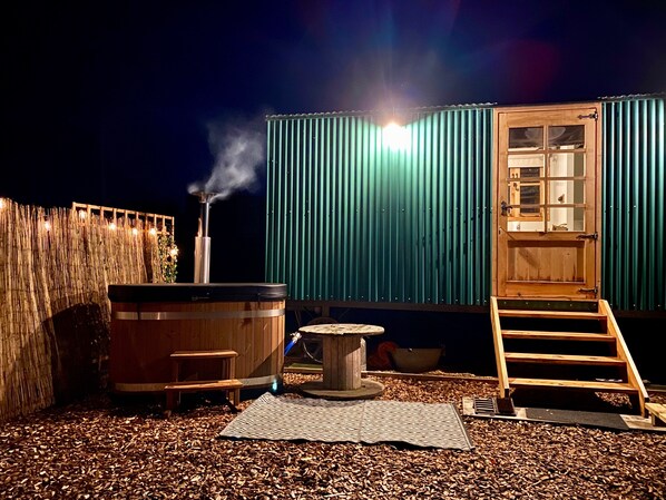 A hot tub, a wooden deck, and a ladder leading to a door. - Shepherd Hut Rutland Water (Oakham)
