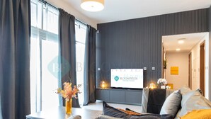 Una sala de estar moderna con un sofá, una mesa de centro y un televisor de pantalla plana montado en la pared.