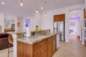 A modern kitchen with granite countertops, stainless steel appliances, and wooden cabinets.