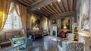 A luxurious room with a glass table, elegant chairs, a patterned armchair, and ornate ceiling details. - Palazzo Borghese, a Burghesius home (Roma)