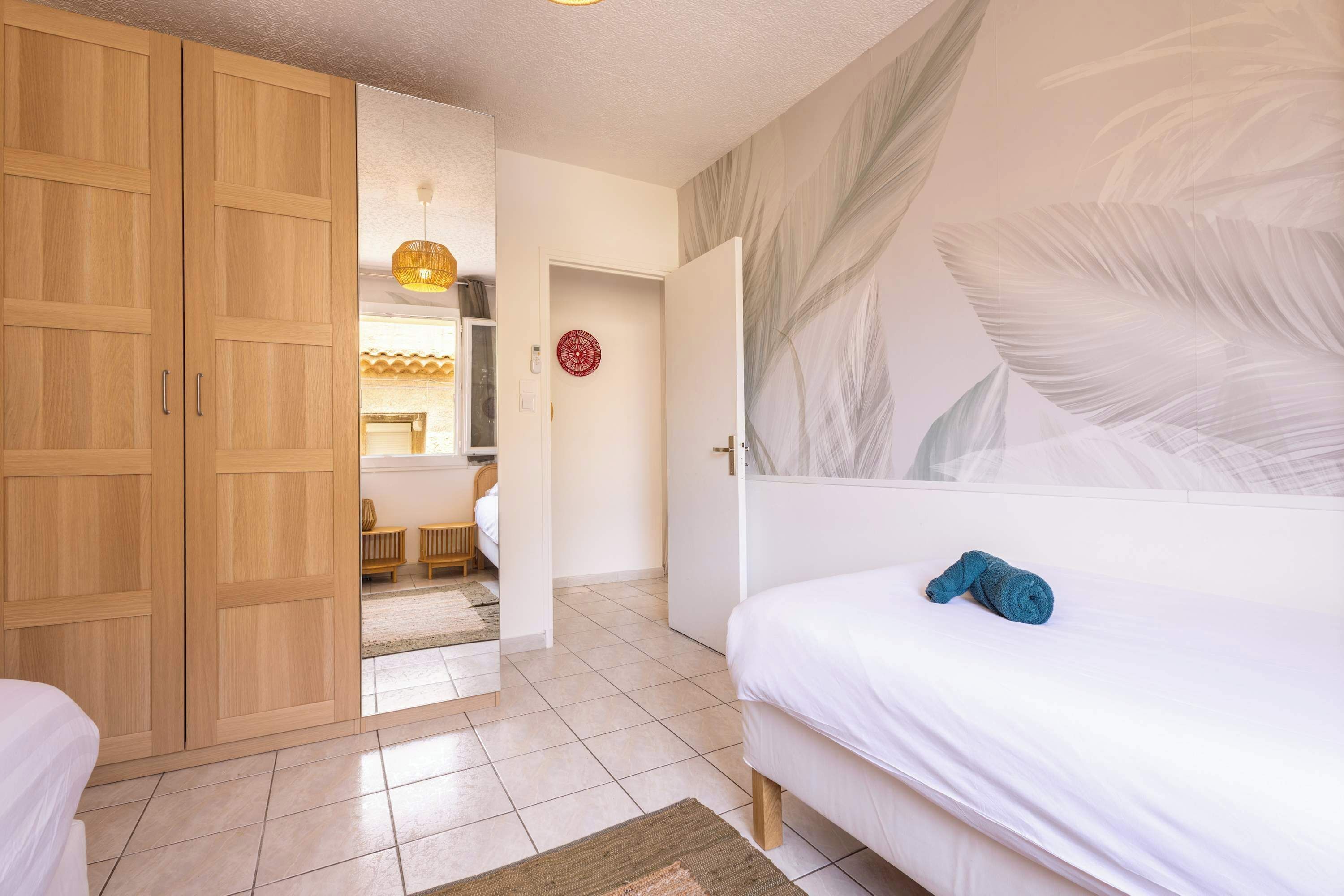 A bedroom with a bed, a wardrobe, and a bathroom visible through an open door.