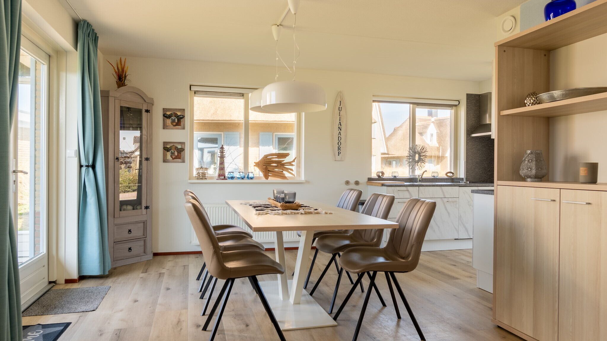 Una cucina moderna con zona pranzo, mobili in legno e un'ampia finestra.