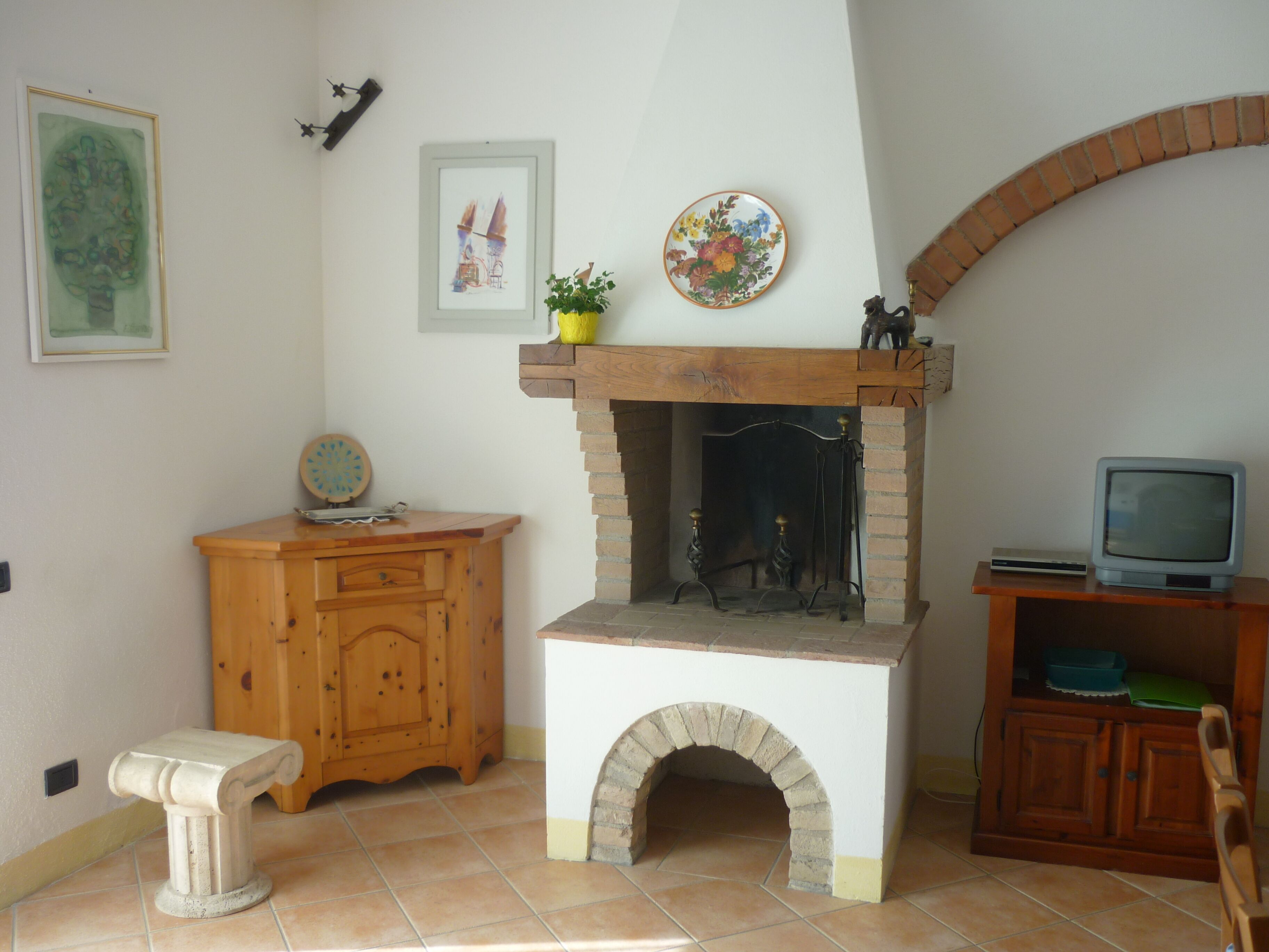Une pièce avec une cheminée, des meubles en bois et un téléviseur.