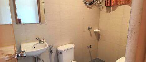 A bathroom with a toilet, sink, and mirror.