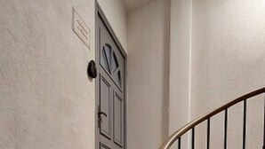 Un escalier en colimaçon, doté d’une rampe et d’une porte en haut.