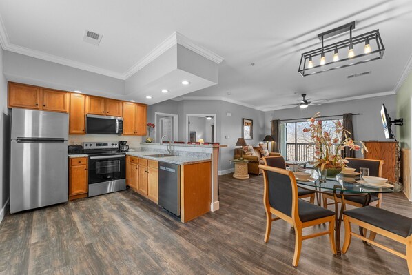 A modern kitchen with stainless steel appliances, wooden cabinets, and a central island.