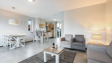 Un salon moderne comprenant un coin repas, une cuisine et offrant une vue sur l’extérieur.