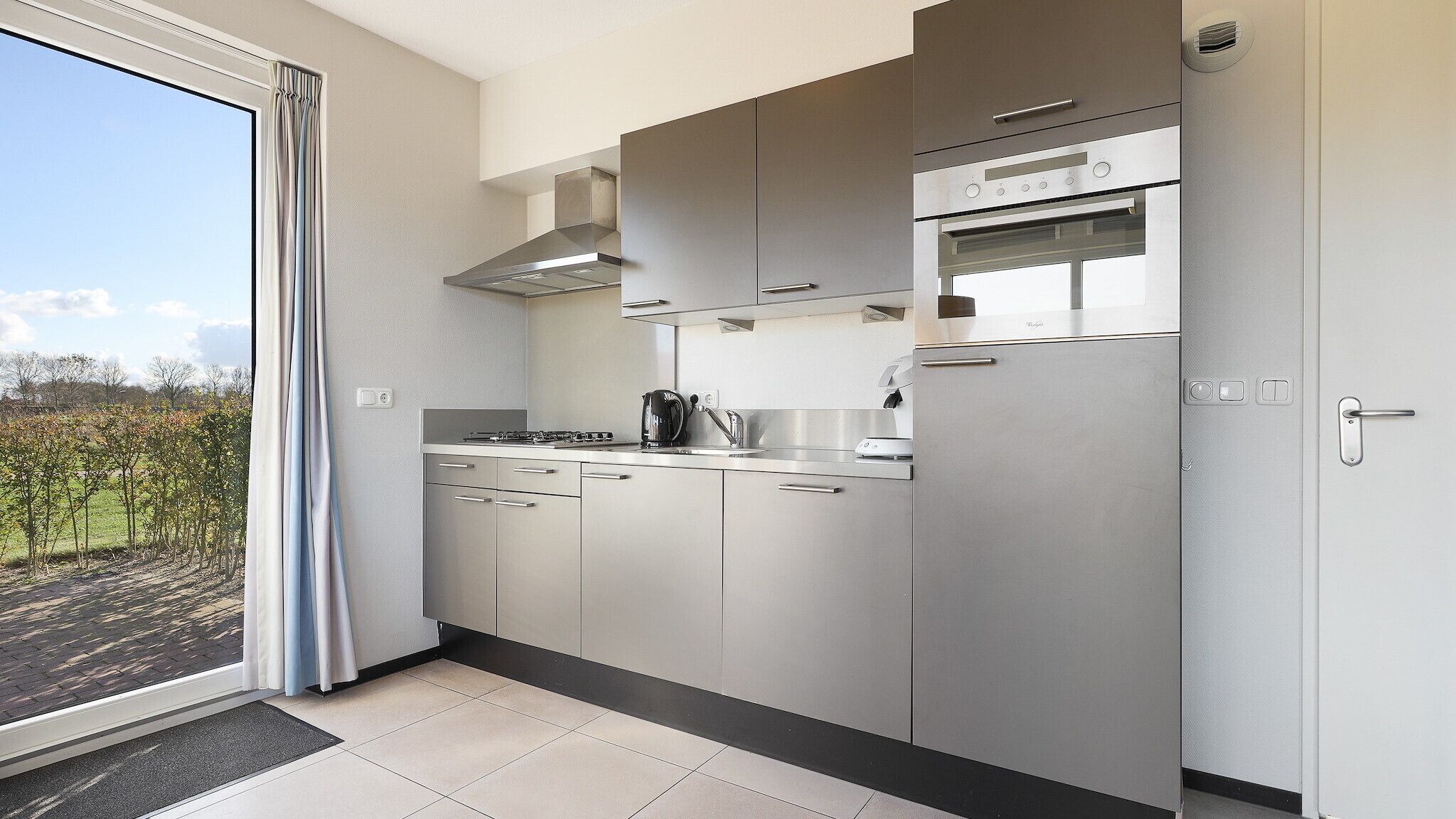 Une cuisine moderne équipée d’appareils électroménagers en acier inoxydable, d’une cuisinière à gaz et d’un four encastré.