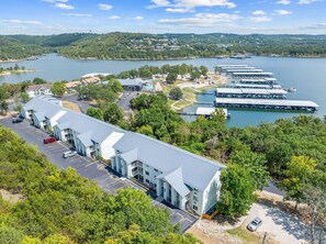 A large hotel with multiple buildings, a parking lot, and a marina with boats.