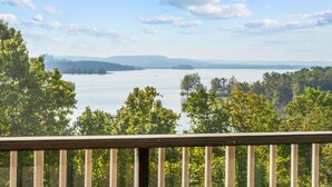 A view of a lake with trees in the foreground and a distant mountain range. - Condo by the Dock: Marina Views & Boat Rentals (Branson)