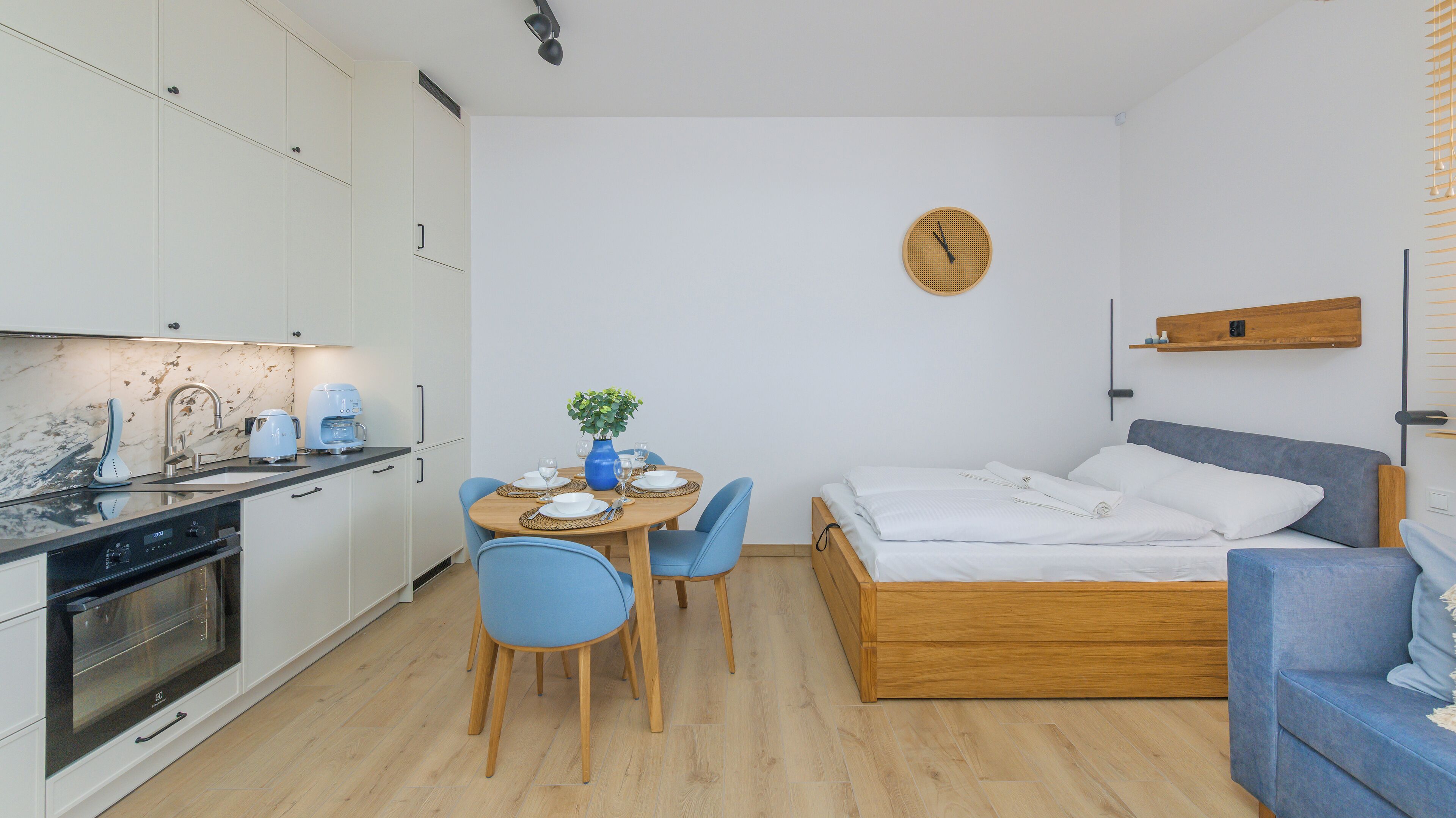 Un apartamento moderno y compacto con kitchenette, comedor y habitación.